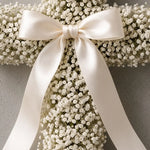 Close-up of white gypsophila and a satin bow in a funeral cross — IFIORA florist, Warsaw (Mokotów)